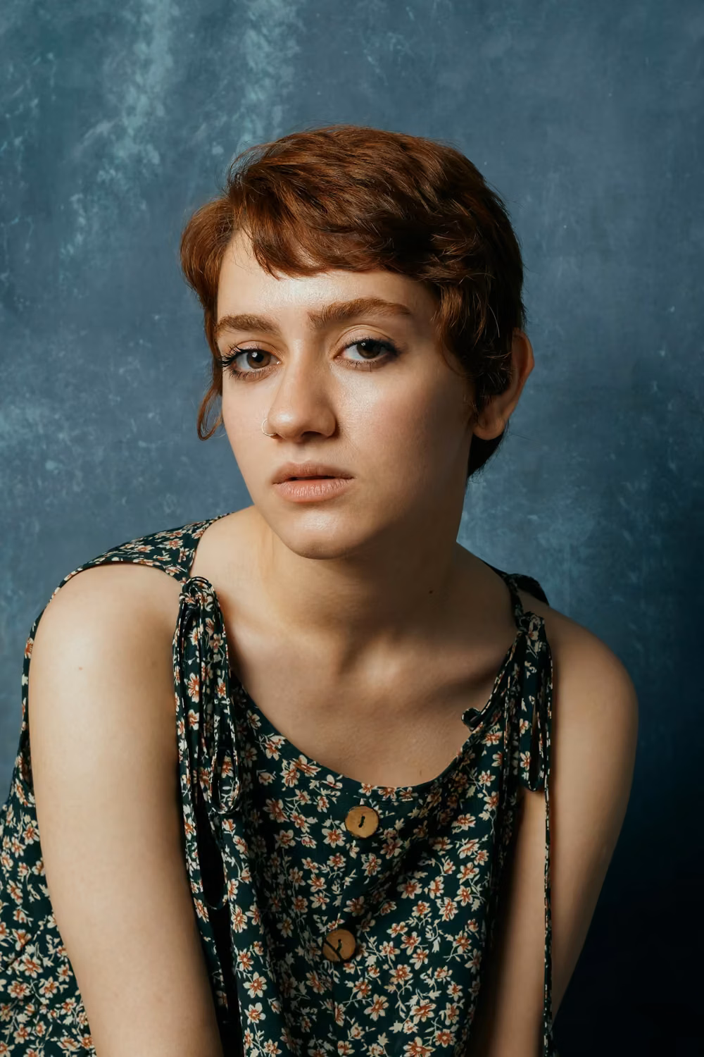 A woman with red hair is sitting down