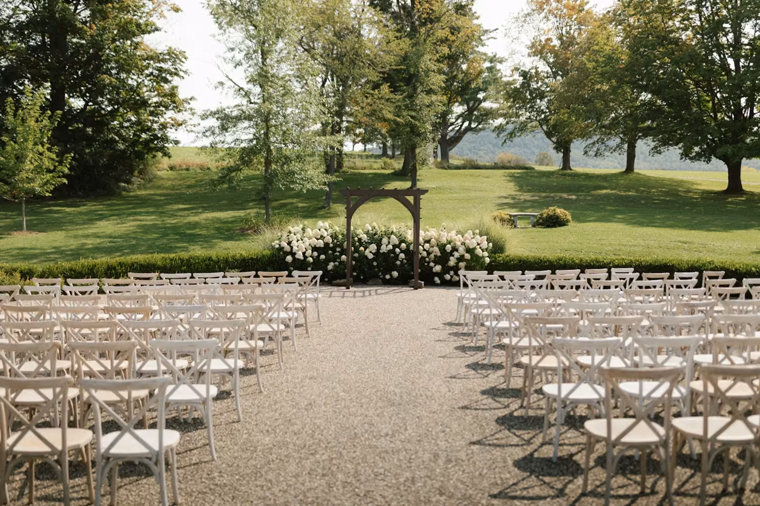 An outdoor ceremony setup with white chairs
