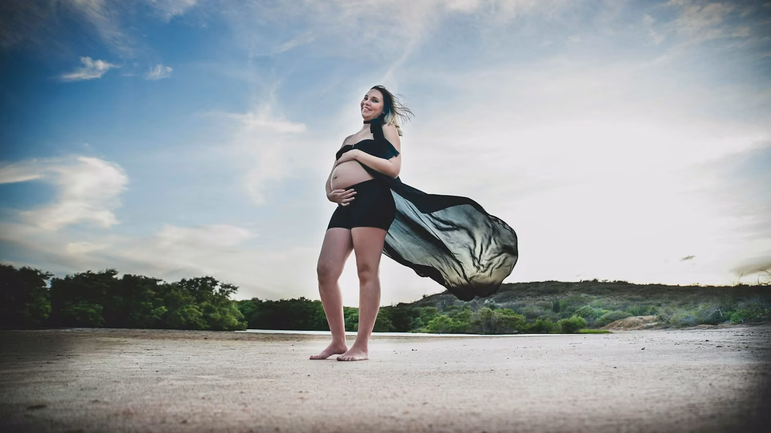 Pregnant woman in black dress with flowing fabric