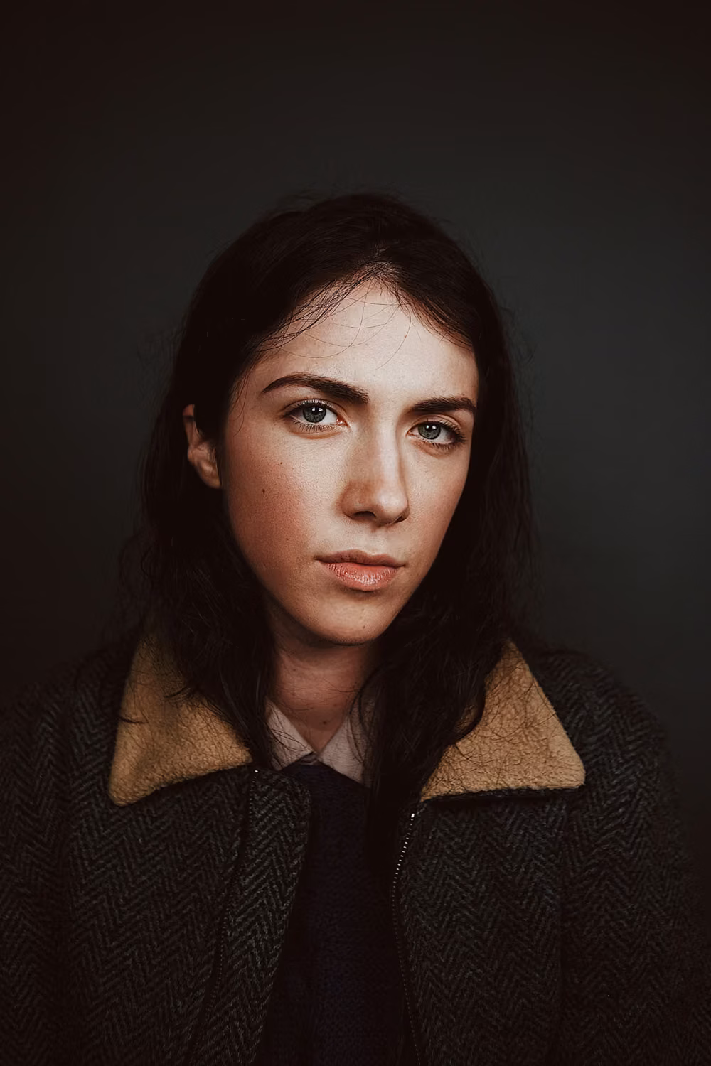 Portrait photograph of woman in gray and brown coat
